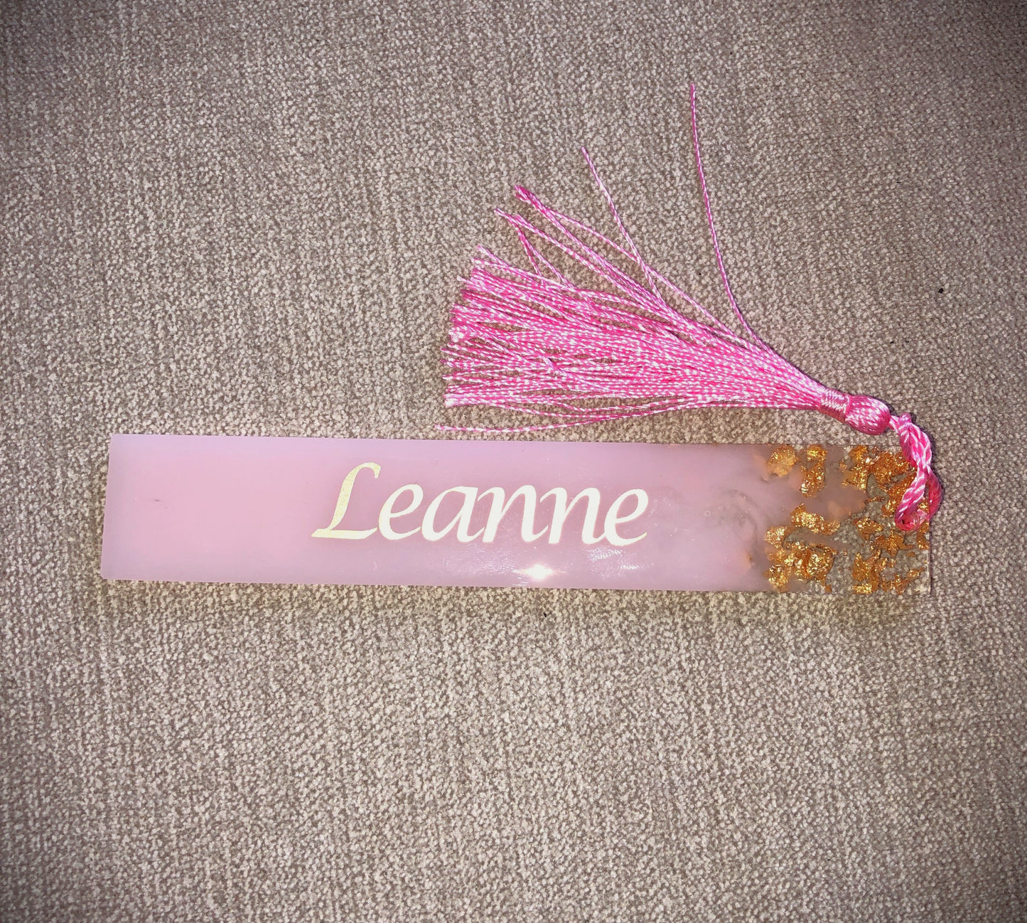 Pink bookmark with Gold flakes of glitter, personalised with name of your choice in gold text and complete with random coloured tassel.