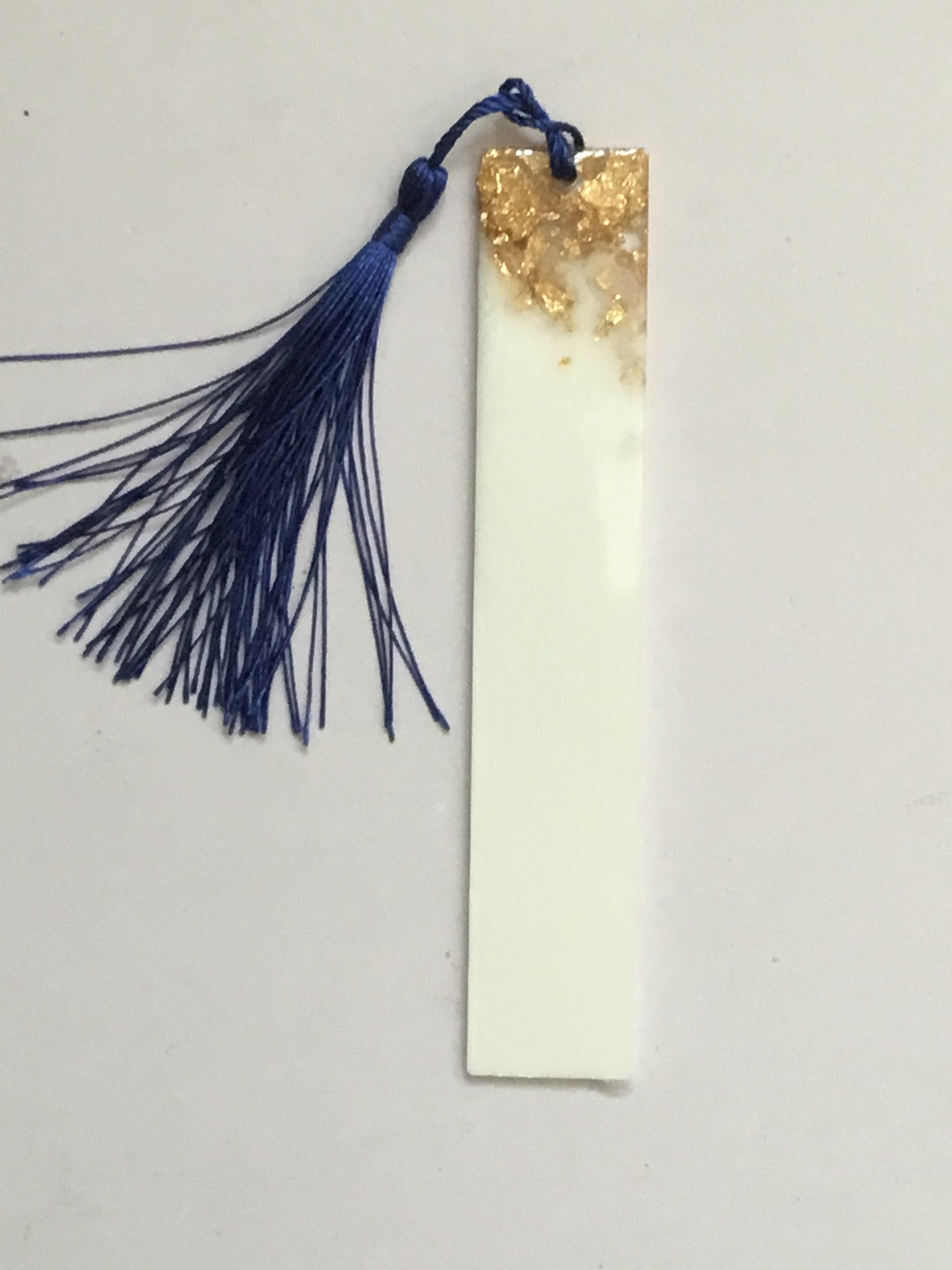 White bookmark with gold flakes of glitter, personalised with name of your choice in gold text and complete with random coloured tassel