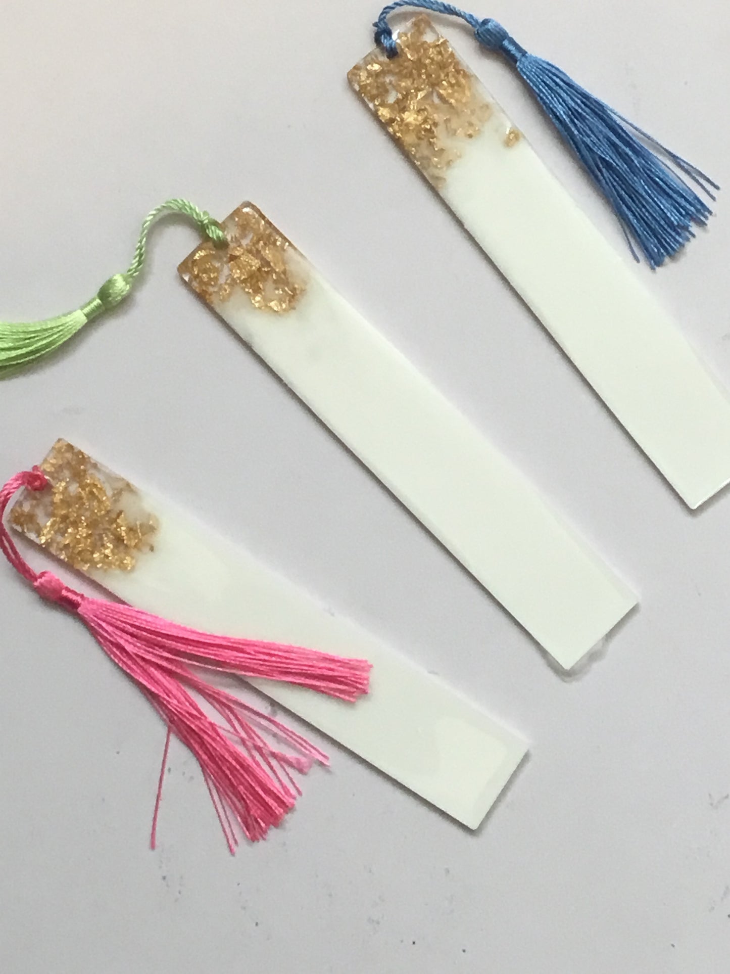 White bookmark with gold flakes of glitter, personalised with name of your choice in gold text and complete with random coloured tassel.